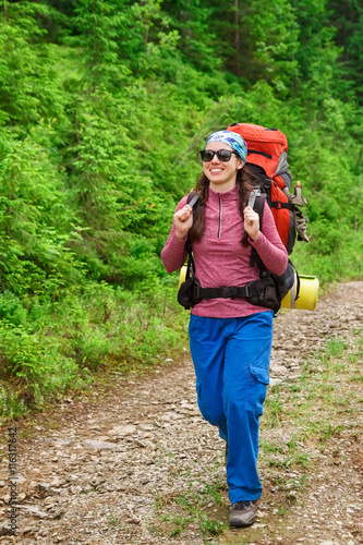 Girl tourist with a backpack going to the mountain