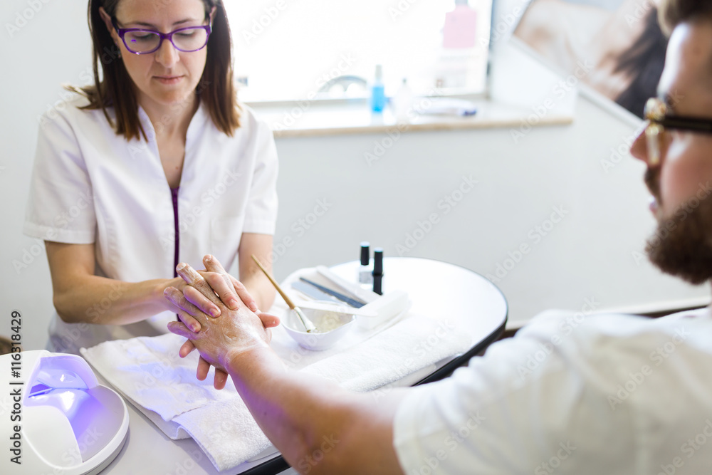 Young man doing manicure in salon. Beauty concept. Young man doing manicure in salon. Beauty concept.