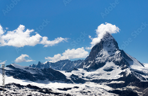 Matterhorn mountain with few cloud cover at the peak, snow patch