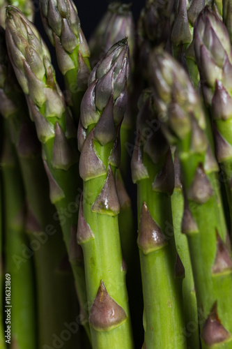 Bunch of asparagus on a table. Uncooked pile raw for organic, vegetarian cuisine, delicious fresh, healthy ingredient. Closeup and copy space.
