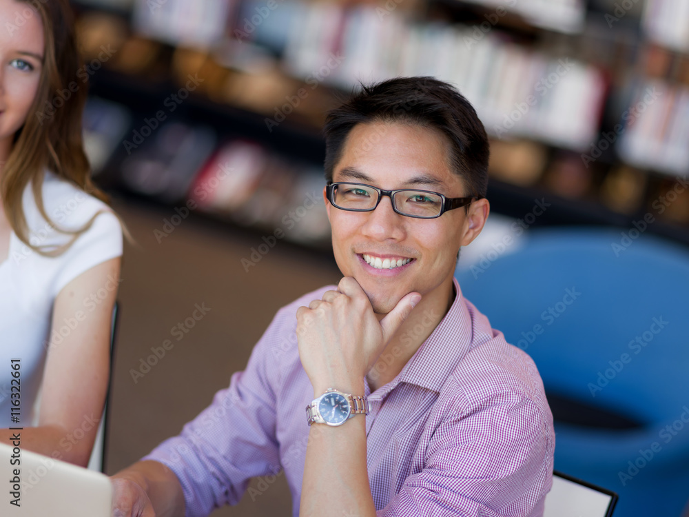 Happy male student working at the library Happy male student working at the library