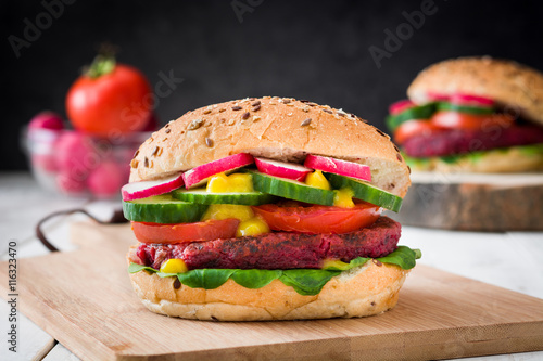 Veggie beet burger on white table and black slate background