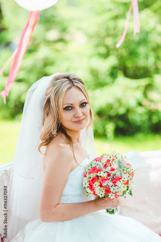Fototapeta premium bride in a beautiful veil for the decorated table, summer wedding in the style of boho. Decorated tree.