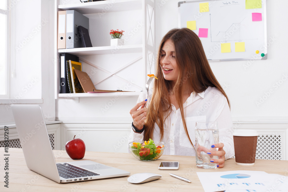 Woman has healthy business lunch in modern office interior Woman has healthy business lunch in modern office interior