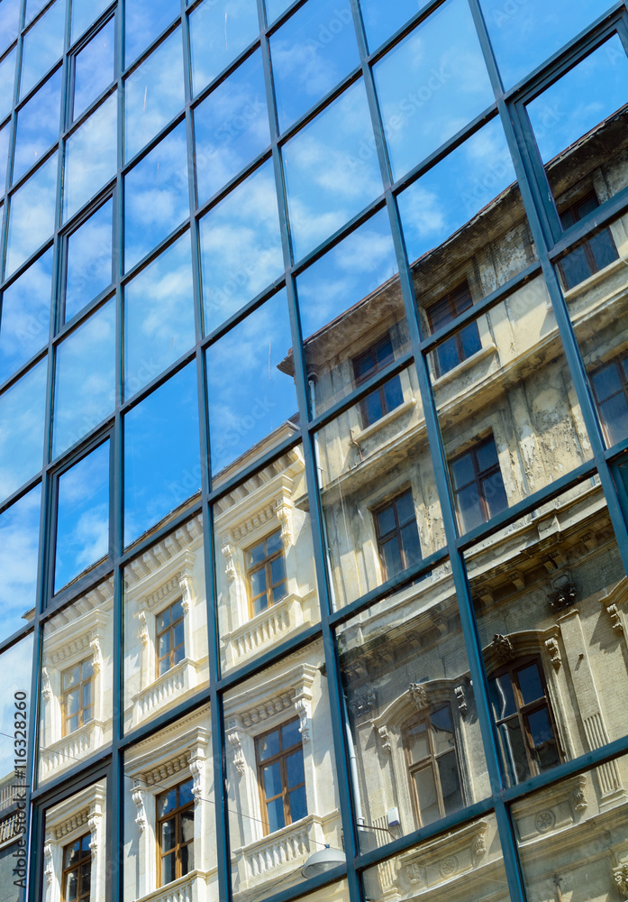 reflection of the old house and the sky with clouds in the windows of the new reflection of the old house and the sky with clouds in the windows of the new