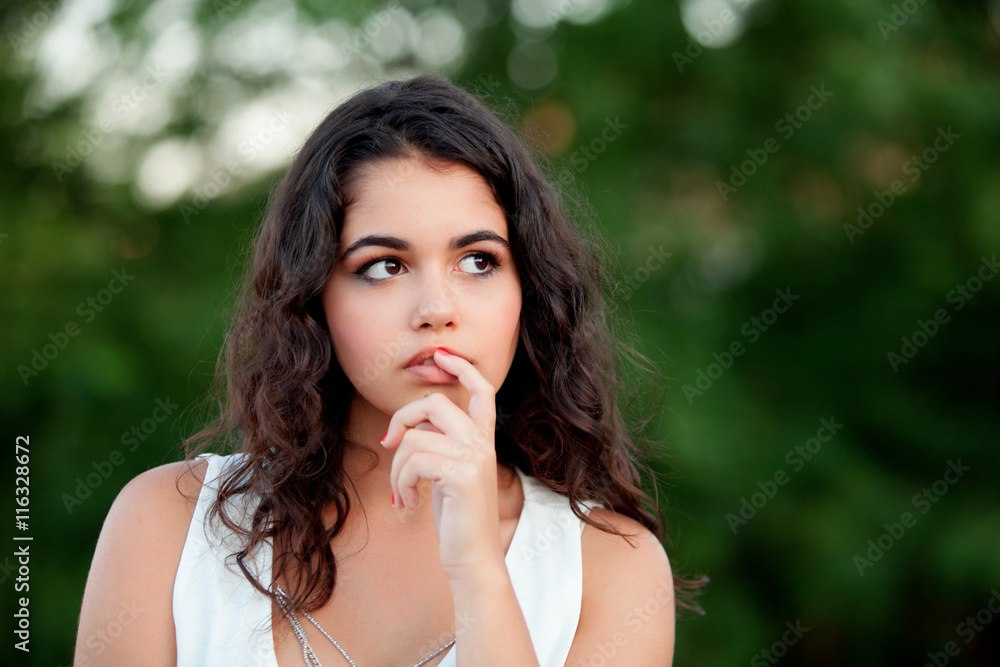 Pensive beautiful brunette girl relaxing in the park Pensive beautiful brunette girl relaxing in the park