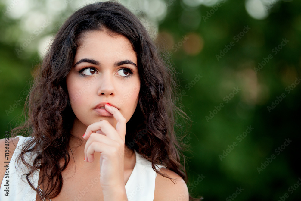 Pensive beautiful brunette girl relaxing in the park Pensive beautiful brunette girl relaxing in the park
