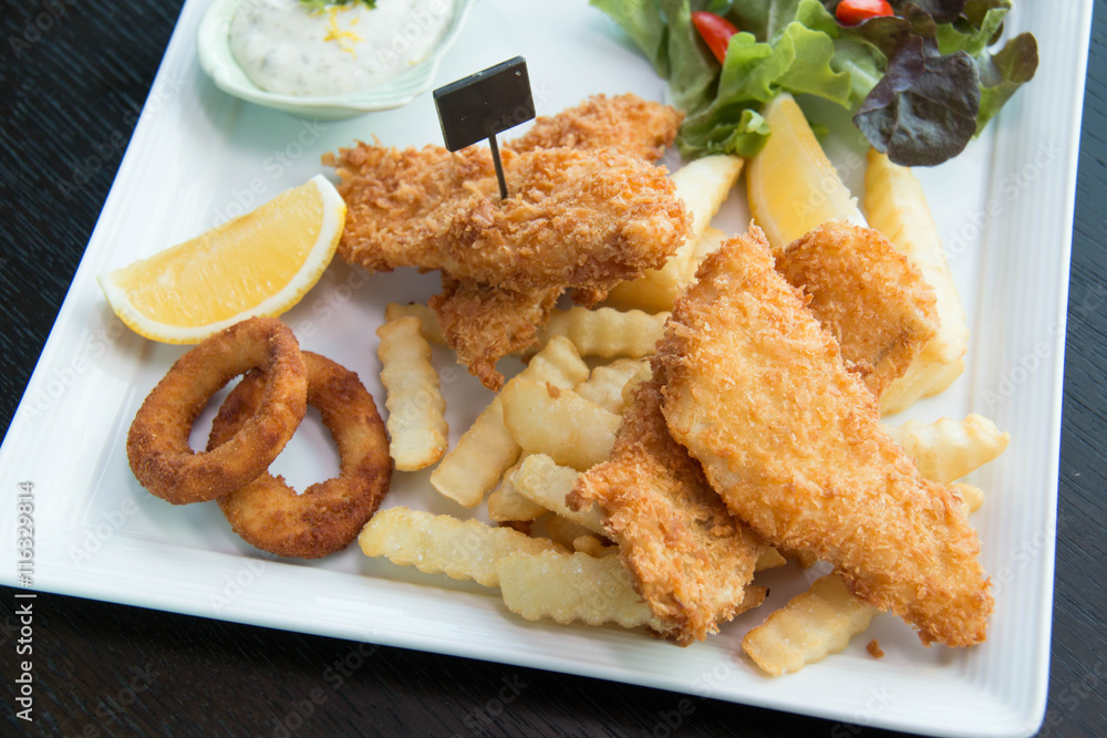 Fish and chips served with cream and vegetables Fish and chips served with cream and vegetables