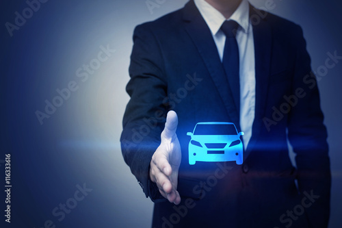 Close up of businessman holding car icon