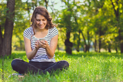 Woman using smart phone in park