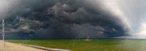Storm and windsurfer.
Approaching storm and floating away sail boat 