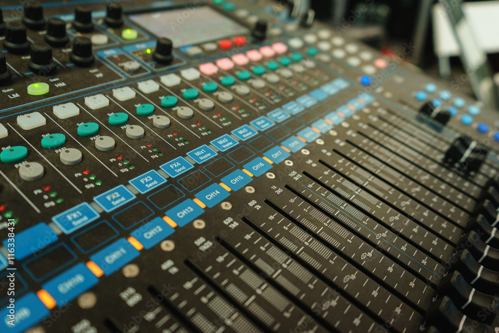 Black professional mixer with buttons and sliders to control the audio output power amplifier speakers. Black professional mixer with buttons and sliders to control the audio output power amplifier speakers.
