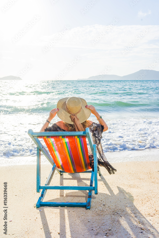 Young woman in hat sitting on beach Young woman in hat sitting on beach