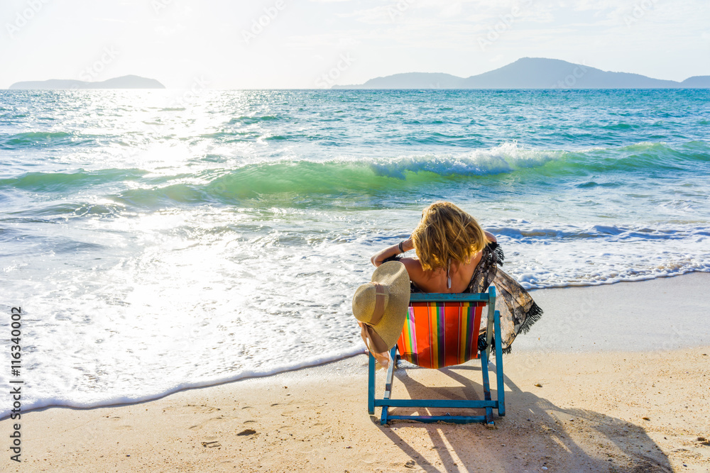 Young woman in hat sitting on beach Young woman in hat sitting on beach