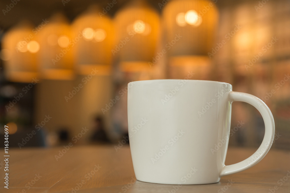 Fototapeta premium white coffee mug on the wooden table in the coffee shop with cozy