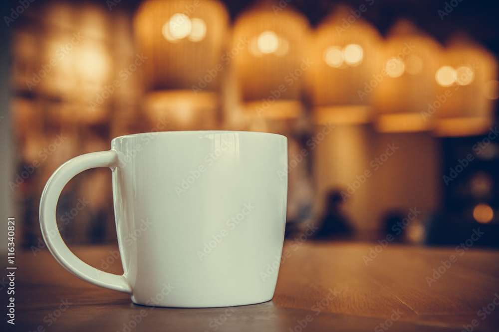 white coffee mug on the wooden table in the coffee shop with cozy white coffee mug on the wooden table in the coffee shop with cozy