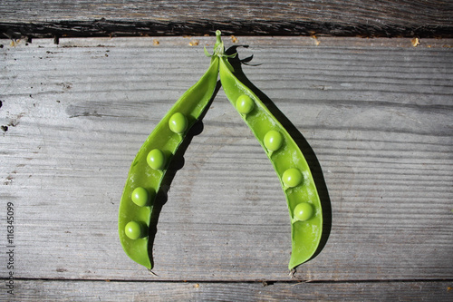 opened pea pod on the wooden table