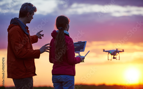 man operating of flying drone at sunset photo