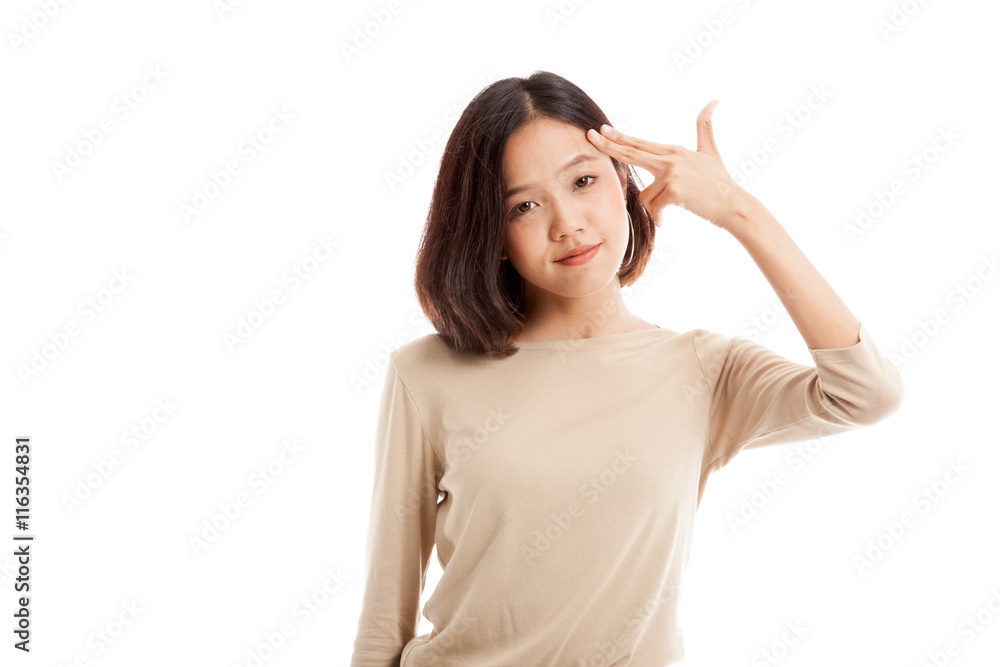 Beautiful young Asian woman holding fingers in gun gesture isolated on white background Beautiful young Asian woman holding fingers in gun gesture isolated on white background