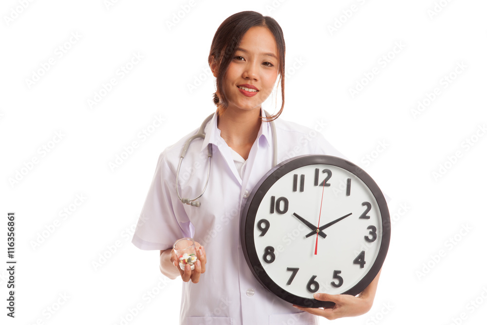 Young Asian female doctor smile with a clock and pills isolated on white background Young Asian female doctor smile with a clock and pills isolated on white background