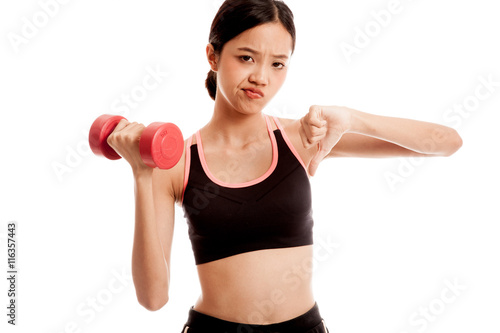 Beautiful Asian healthy girl thumbs down with dumbbell isolated on white background