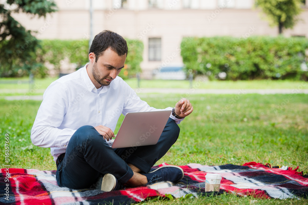 Man is working using laptop at park. Outdoor, guy look challenged and thinking Man is working using laptop at park. Outdoor, guy look challenged and thinking