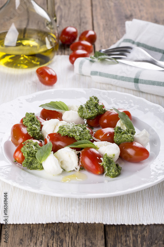 Caprese. Italian salad - mozzarella, tomato, basil, pesto.