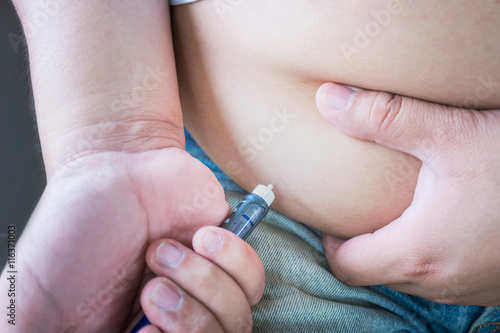 Male diabetes patient injecting insulin in his abdomen area