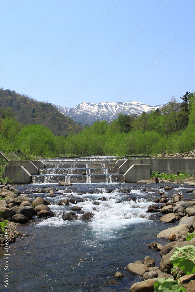 Obraz premium A mountain and river of the spring remaining snow