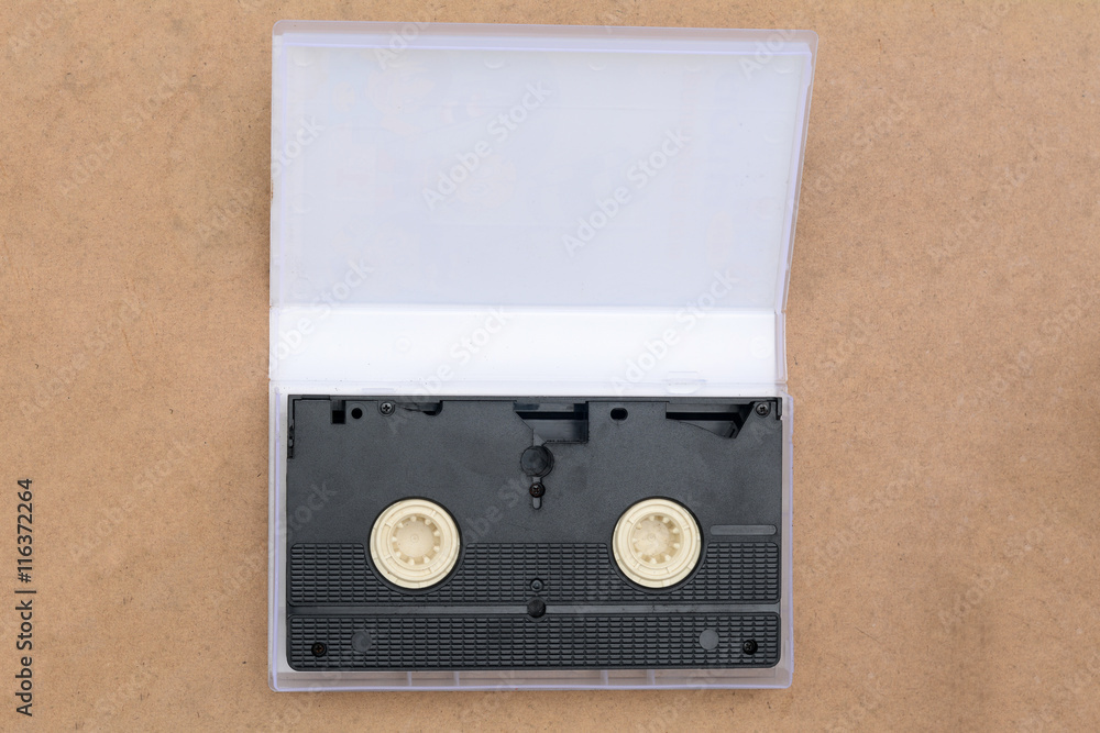 Fototapeta premium pile of videotapes on brown wooden floor background