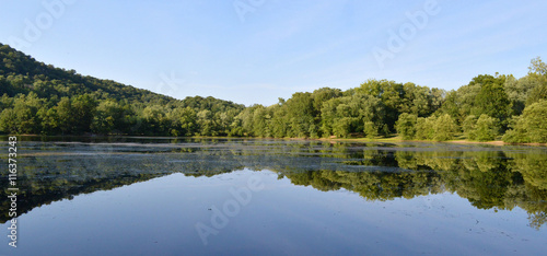 Green mountains and trees with lake reflection