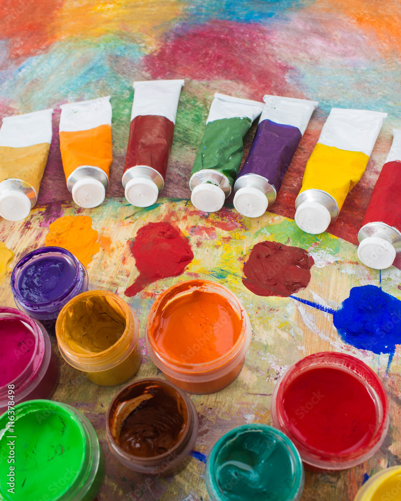 Fototapeta premium Paints, brushes and palette on a color background. The workplace of the artist. Banner for school