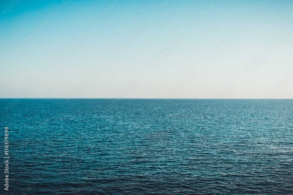 Calm blue ocean background with blue sky