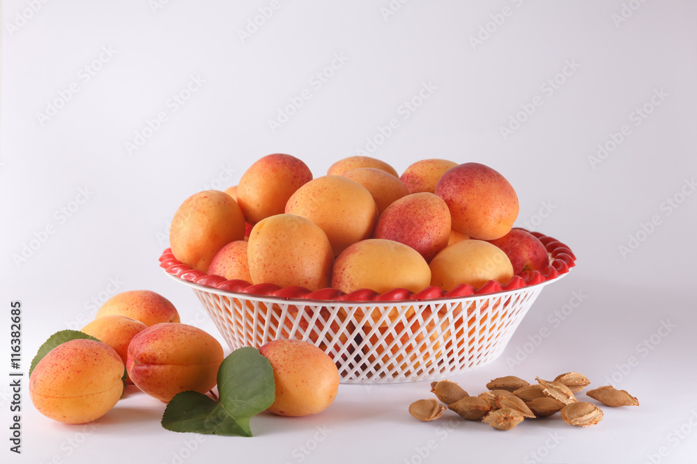 Apricots in a bowl and a few apricots and pits Apricots in a bowl and a few apricots and pits