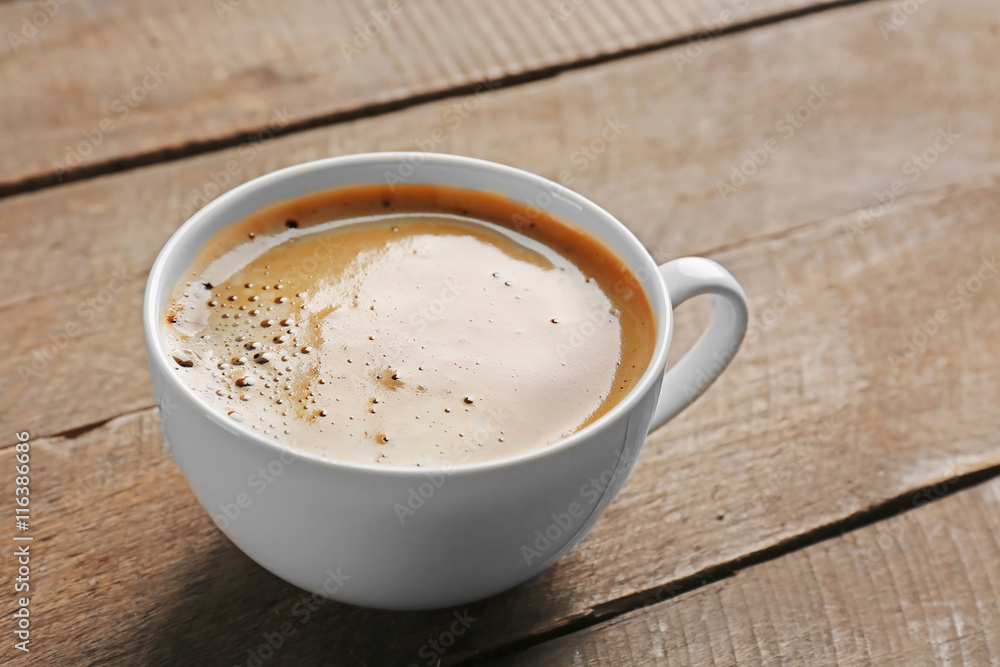 White cup of coffee on wooden background White cup of coffee on wooden background