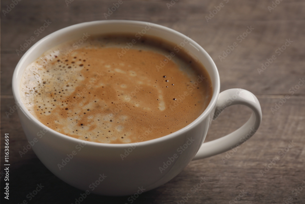 White cup of coffee on wooden background White cup of coffee on wooden background