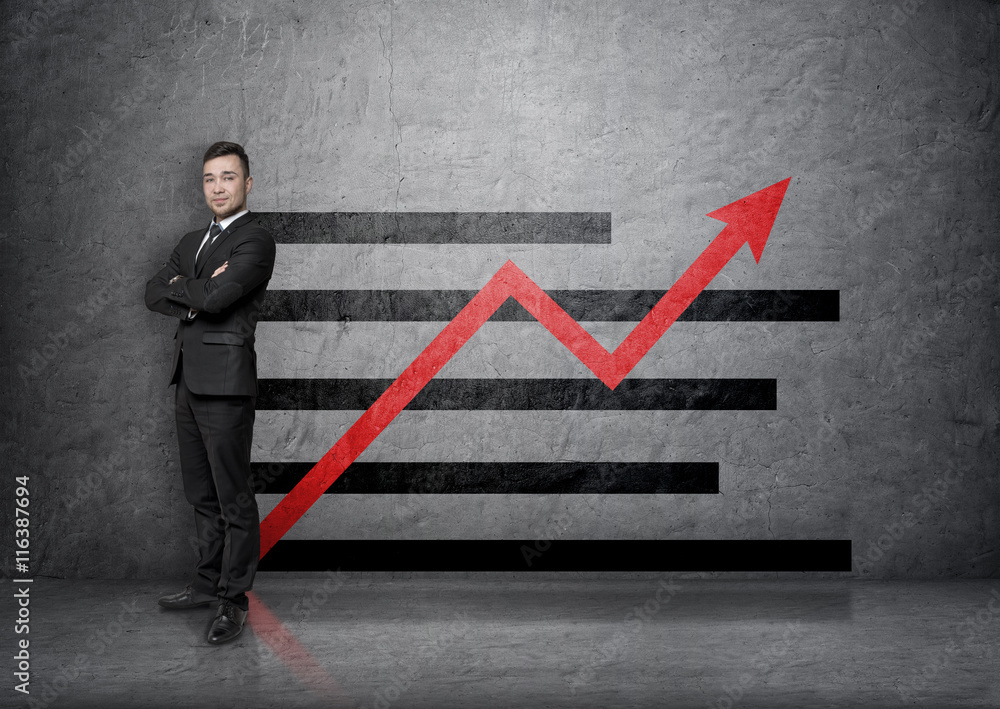 Full portrait of young businessman on a concrete background with increasing graph Full portrait of young businessman on a concrete background with increasing graph