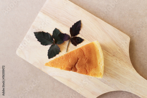 Pieces of Japanese style Cheesecake, top view on wooden plate.