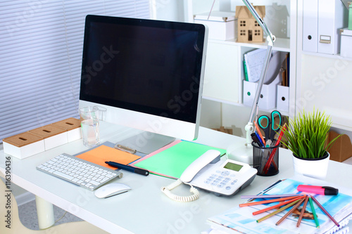 Designer working desk with a computer and paperwork