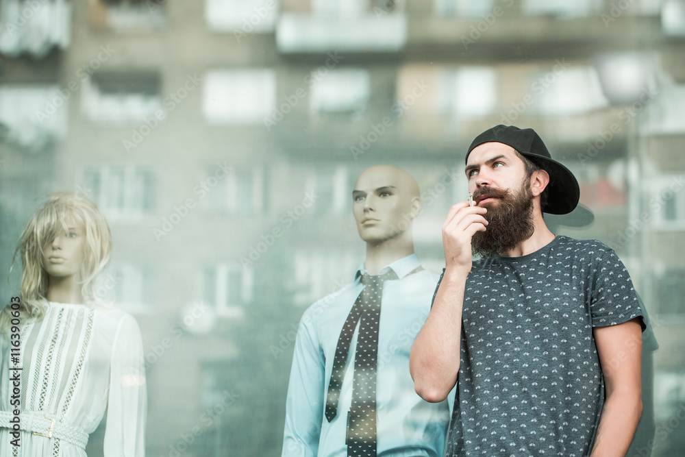 Fototapeta premium bearded man smoking near showcase
