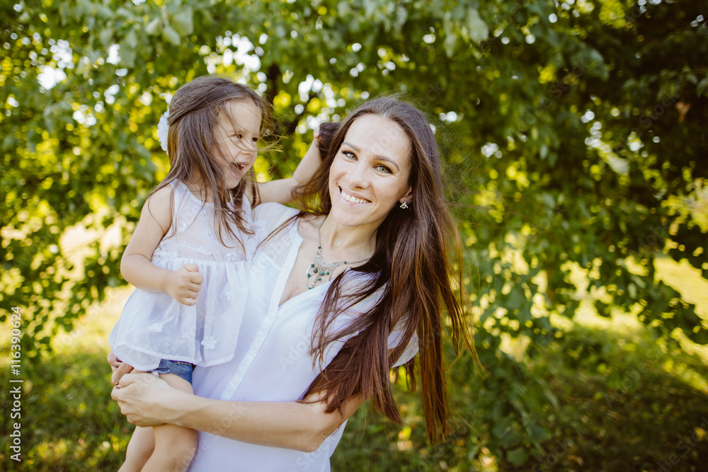 Fototapeta premium Happy mother and daughter laughing together outdoors