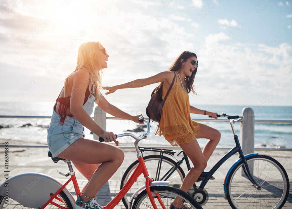 © Jacob Lund - Two friends out for a bike ride on seaside promenade © Jacob Lund - Two friends out for a bike ride on seaside promenade