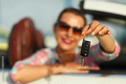 Woman sitting in a convertible car with the keys in hand - conce