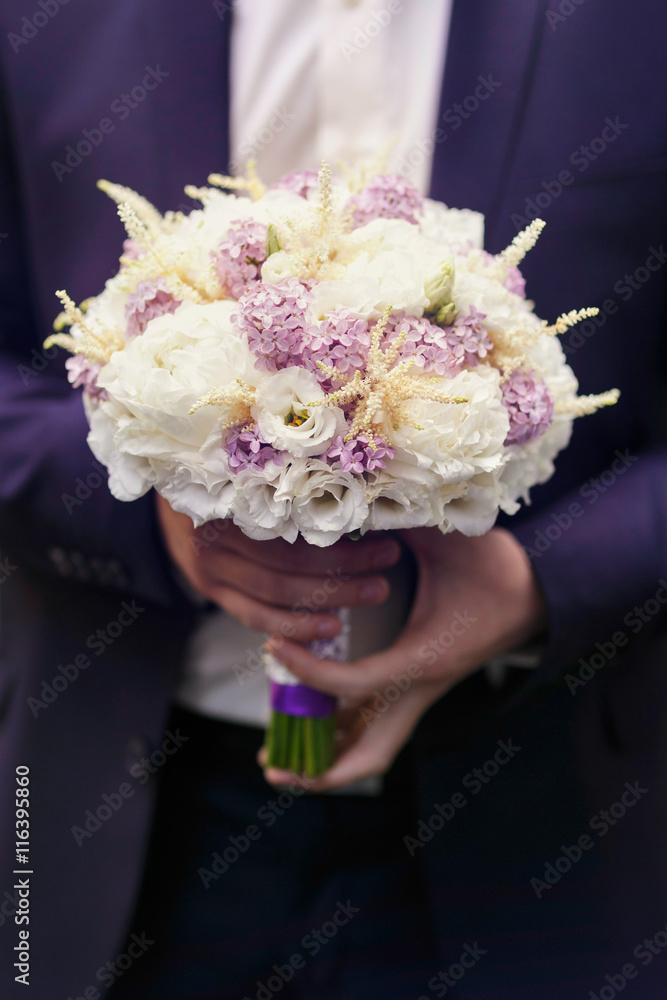 Hroom holds a tender wedding bouquet of white roses and violet l Hroom holds a tender wedding bouquet of white roses and violet l