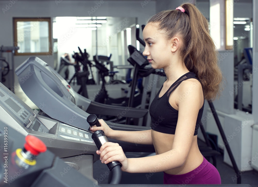 Girl is engaged in sports and gymnastics in the gym