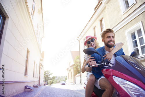 Low angle view of couple on fast scooter.