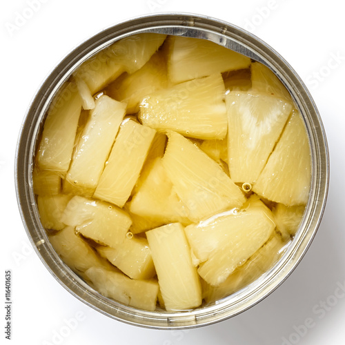 Pieces of pineapple in a tin from above isolated on white.