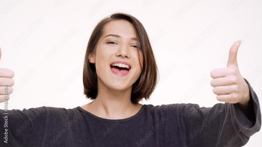 Portrait of young pretty girl rejoicing and showing okay. Slow motion. Portrait of young pretty girl rejoicing and showing okay. Slow motion.