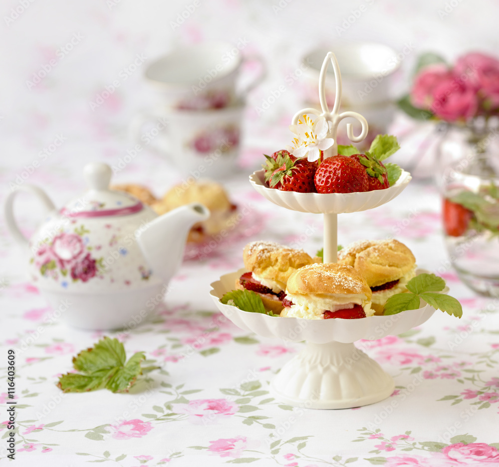 Cream puffs cakes or profiterole filled with whipped cream served with strawberries in plateau