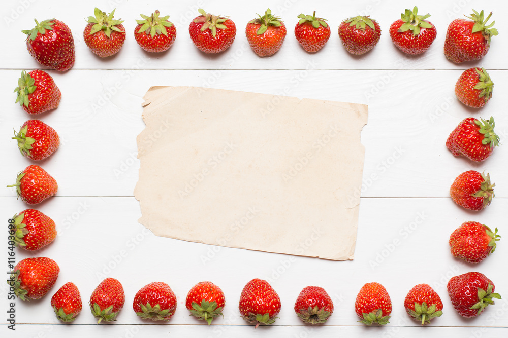 Strawberry frame and paper sheet on table